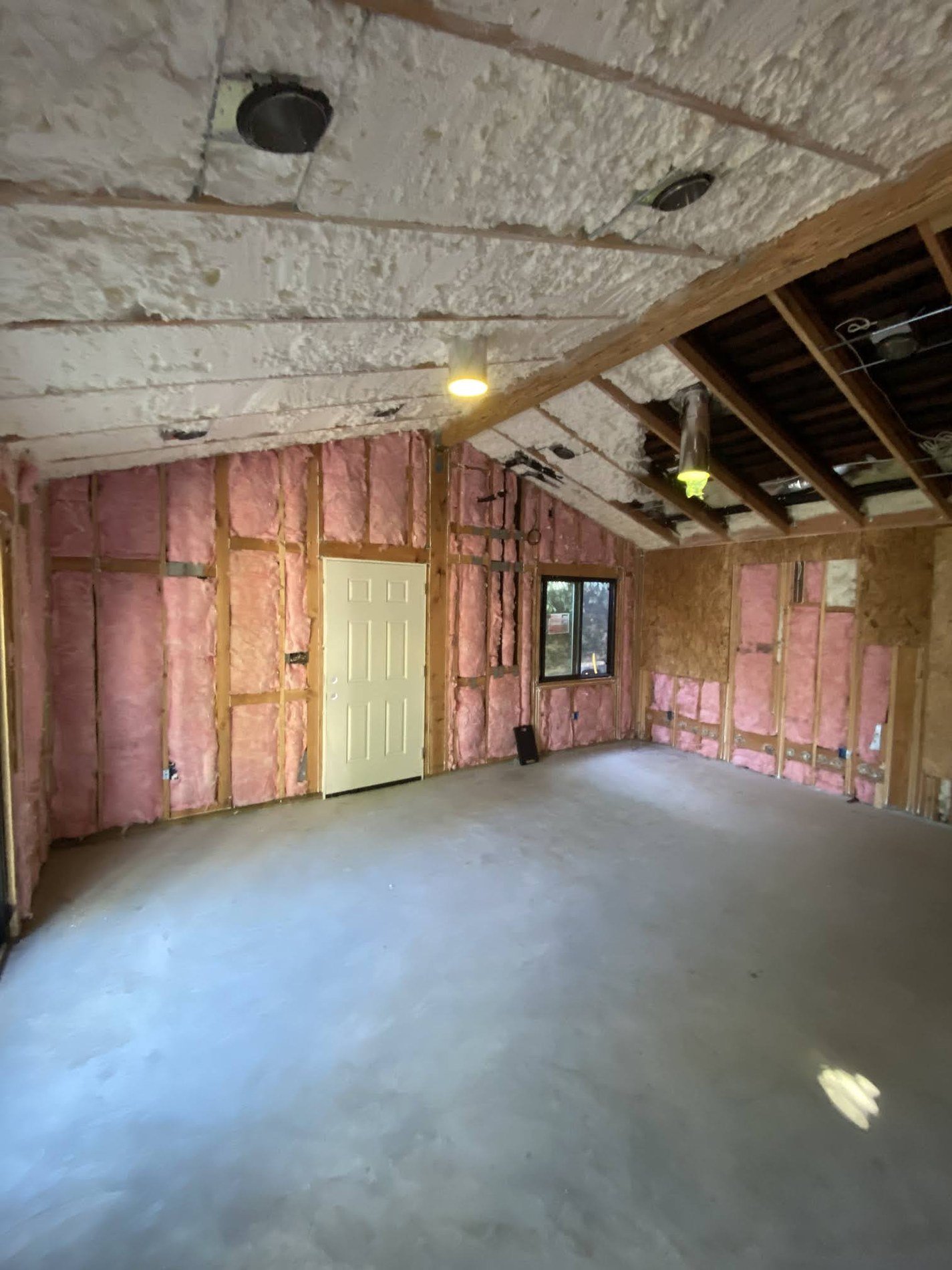 Garage conversion interior with wall insulation and insulated ceiling cavities