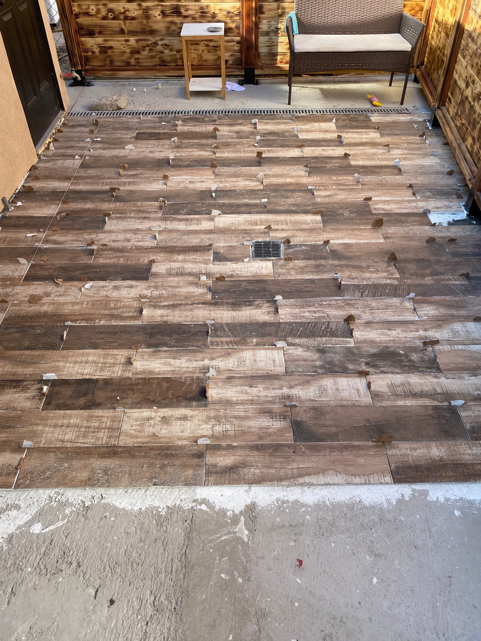 Close view of wood-look tile installation and drain detail
